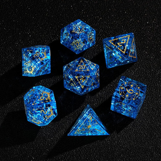 Full polyhedral set of Blue Glass Sharp Edge DND Dice on a black background. Highlighting the gold numbers and crystal clarity.