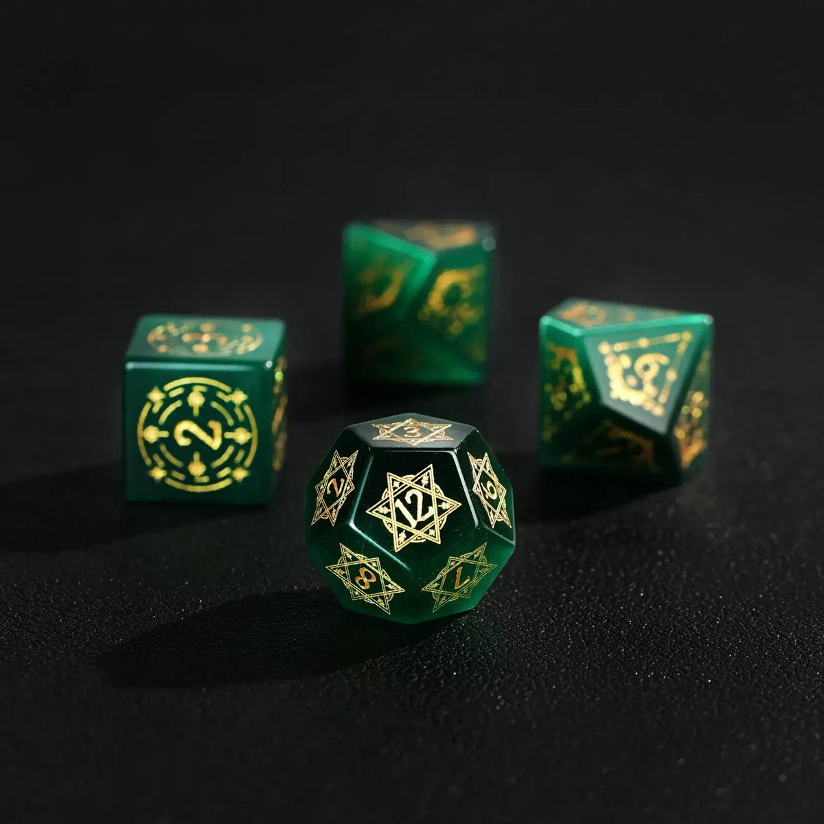 Elegant arrangement of four Dare Green Cat's Eye Dice (D4, D6, D8, D12) with Gold Inking on a solid black background, showcasing the striking color and luminous shine.