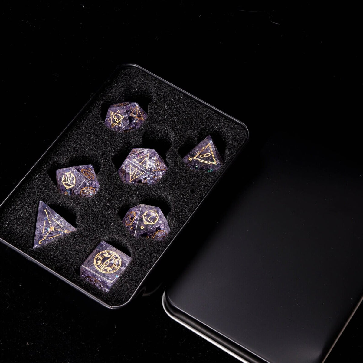 Pink Sharp Edge Dice Set presented inside the open Iron Dice Storage Box. Shows secure dice collection storage.