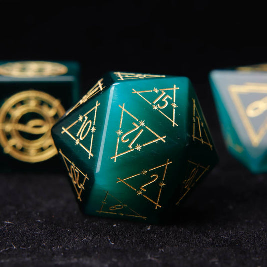 Close-up of the D20 from the engraved gemstone dice set. Deep green cat's eye stone with crisp white engraved numbers, isolated on black.