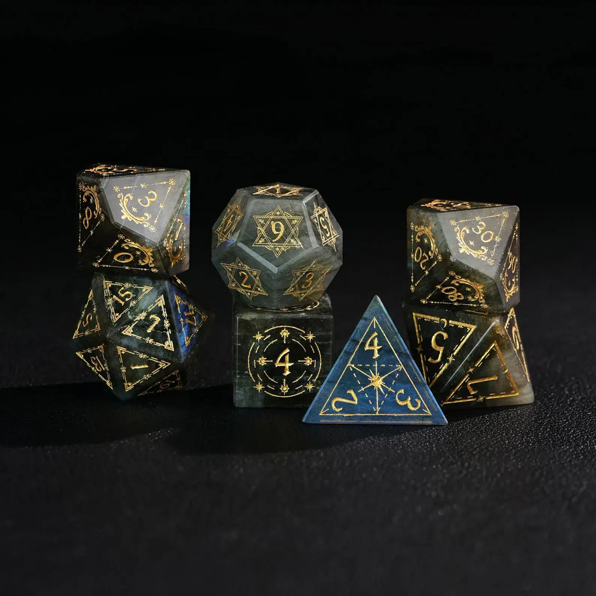 The Blue Labradorite Gemstone DND Dice Setphotographed against a dark background, evoking a celestial, cosmic appearance.