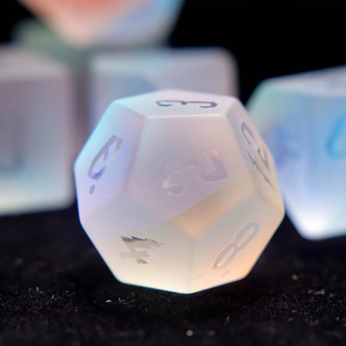 Matte dichroic glass dice rolling in a soft leather dice tray, suggesting the use of a tray to protect the delicate frosted finish.