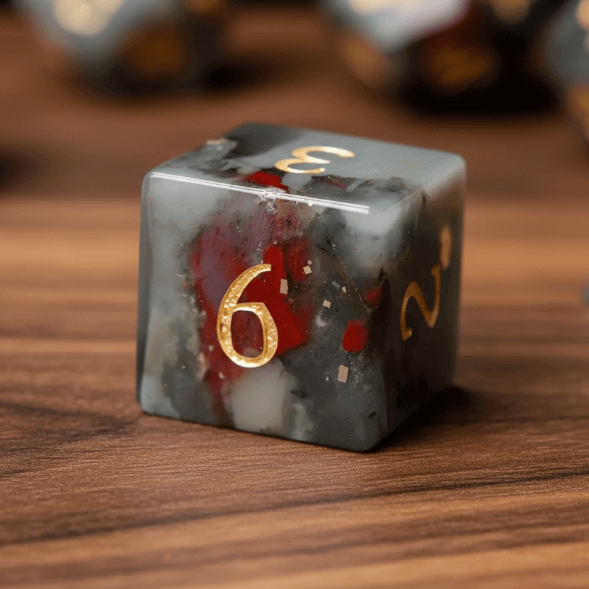 Macro detail showing the natural red and grey speckles (bloodstone texture) of a single die on walnut wood.