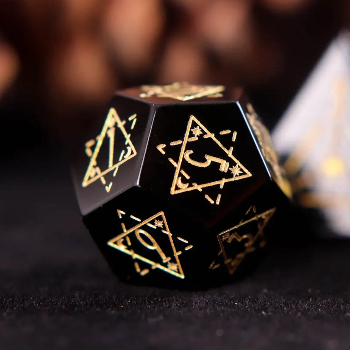 Single hand-carved black Obsidian D12 dice, emphasizing smooth polished edges and elegant pure black finish