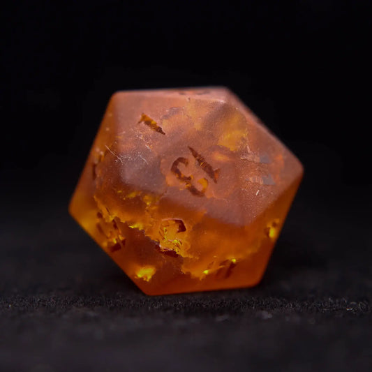 Close up of an orange Gemstone Dice Set d20 with sharp edges