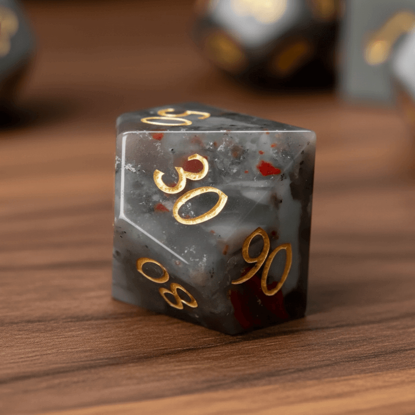 Grey Bloodstone percentile D10 dice (00-90 and 0-9) together on a walnut wood table.