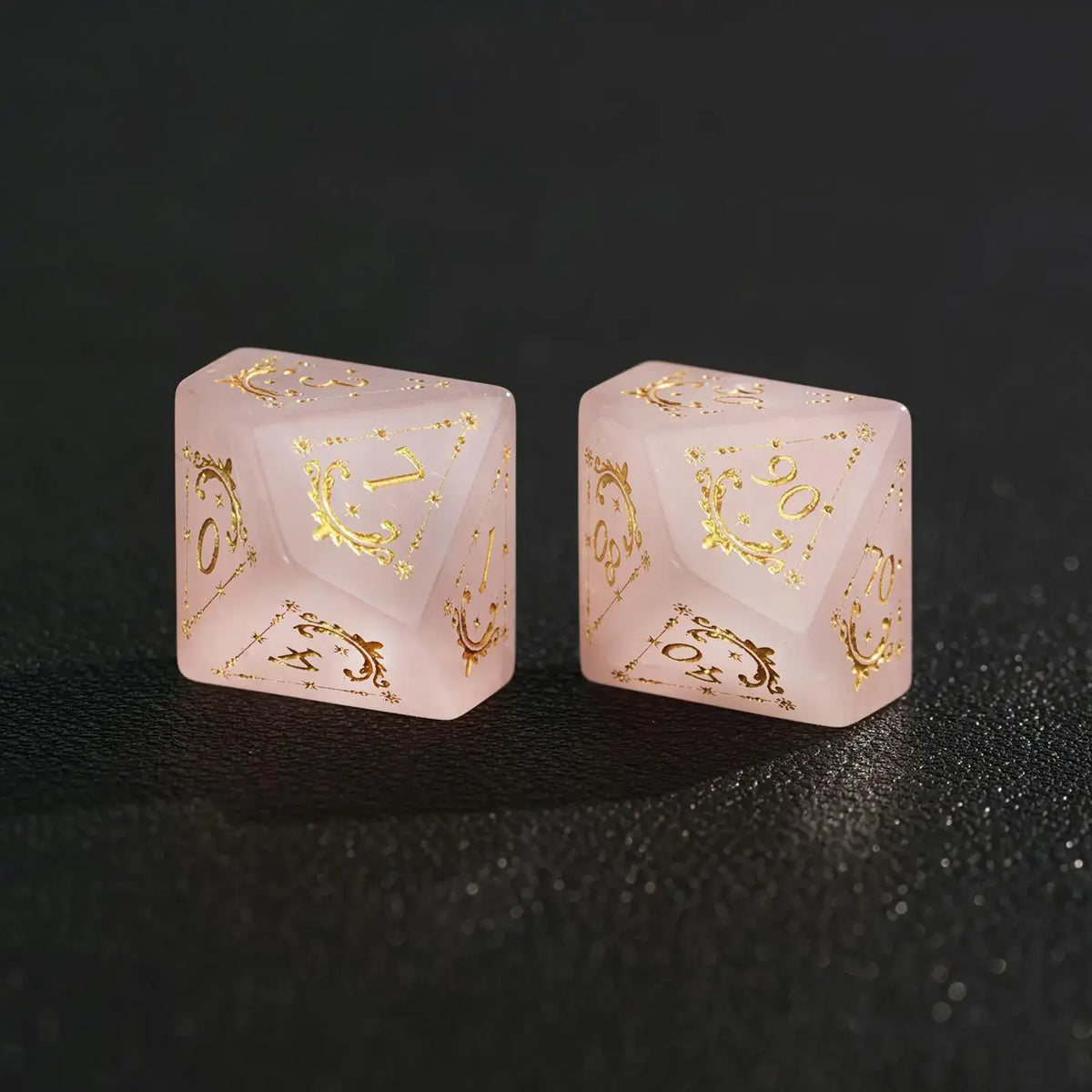 Two Pink Crystal dice (D10 and D%) together on black background, comparing sizes and engraved faces.