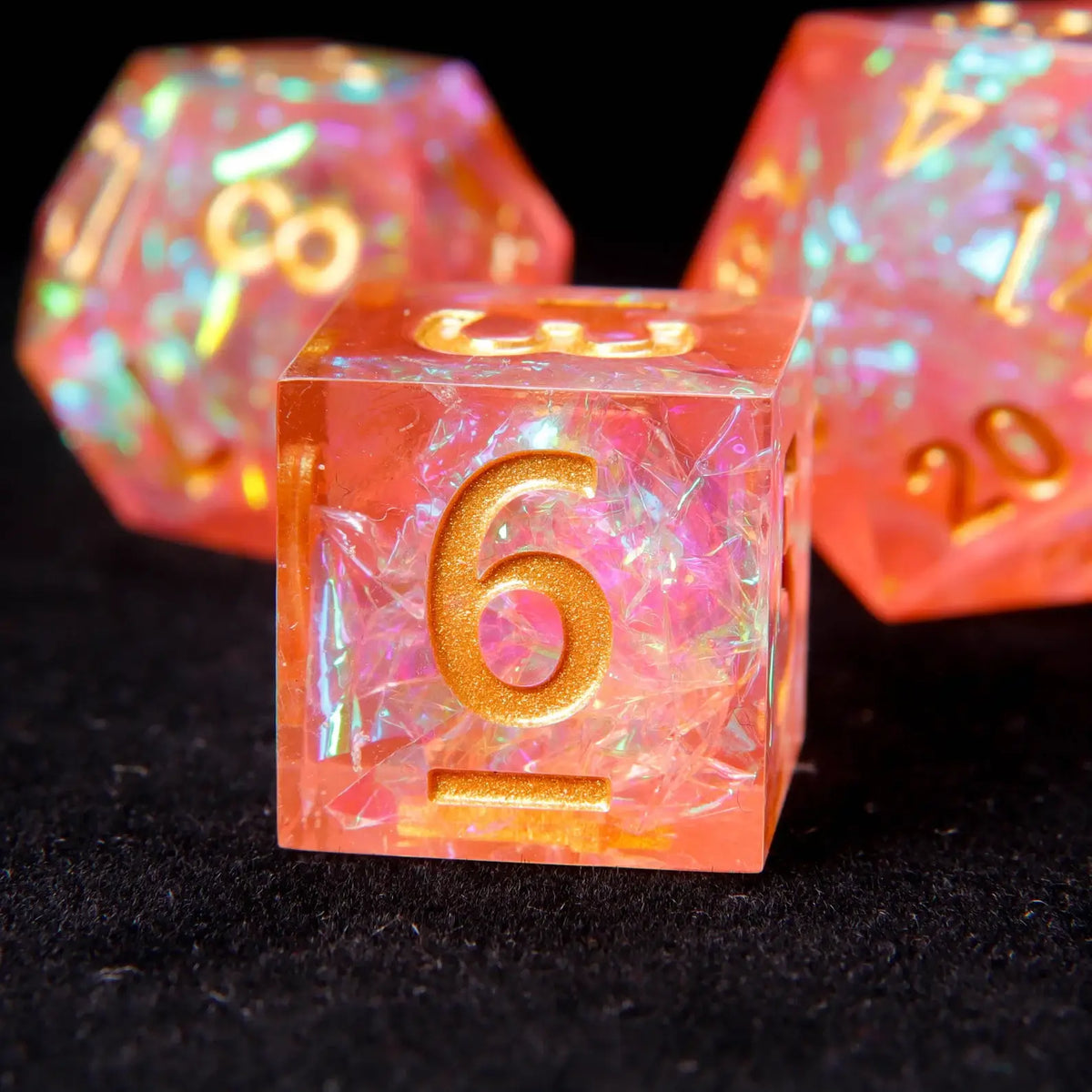Vibrant orange and pink resin dice showing prismatic light refraction