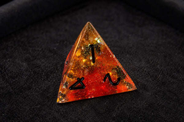 Traditional resin D4 beside a complete seven-piece DND dice set in a felt dice tray.