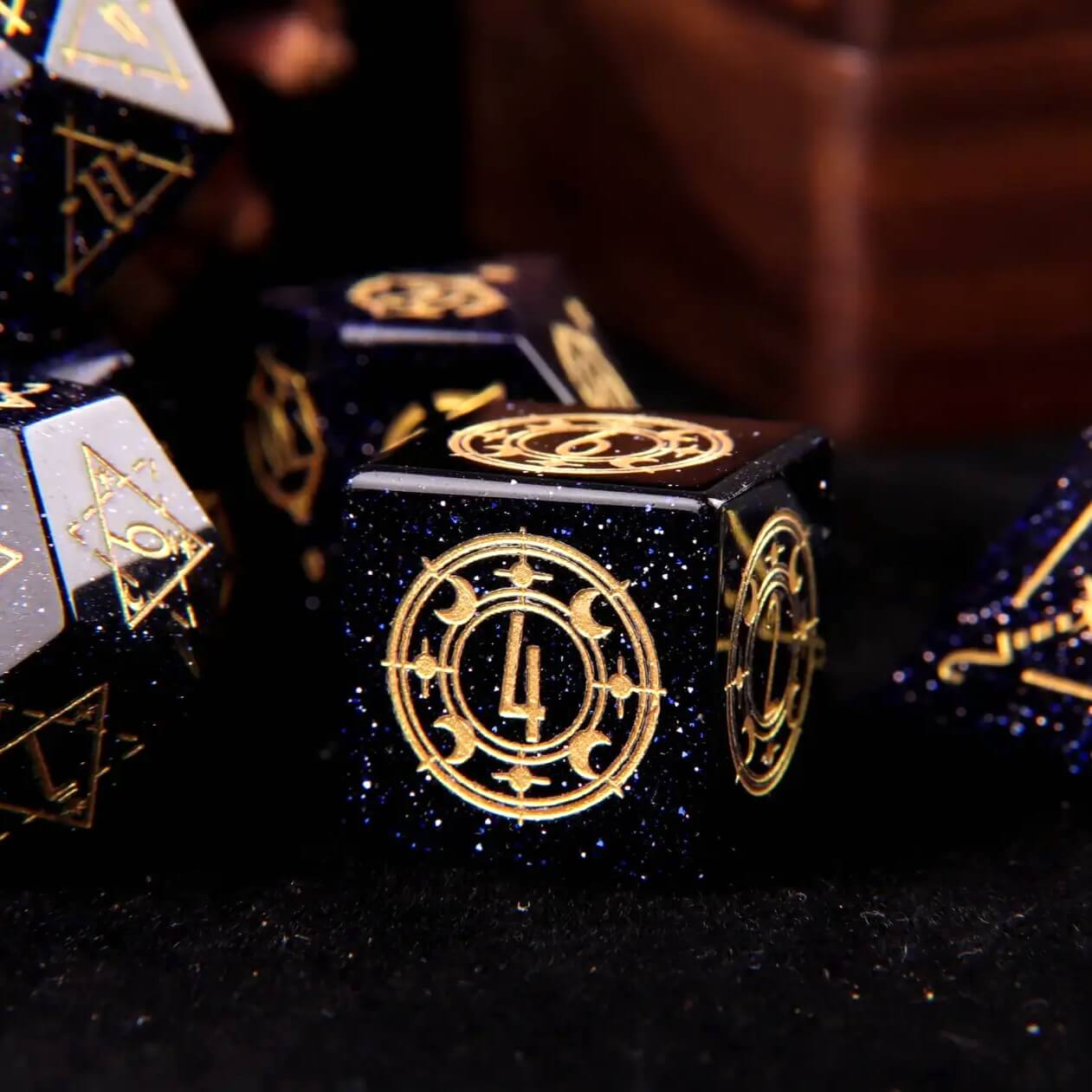 A set of D6 blue sandstone gemstone-carved dice on a black background