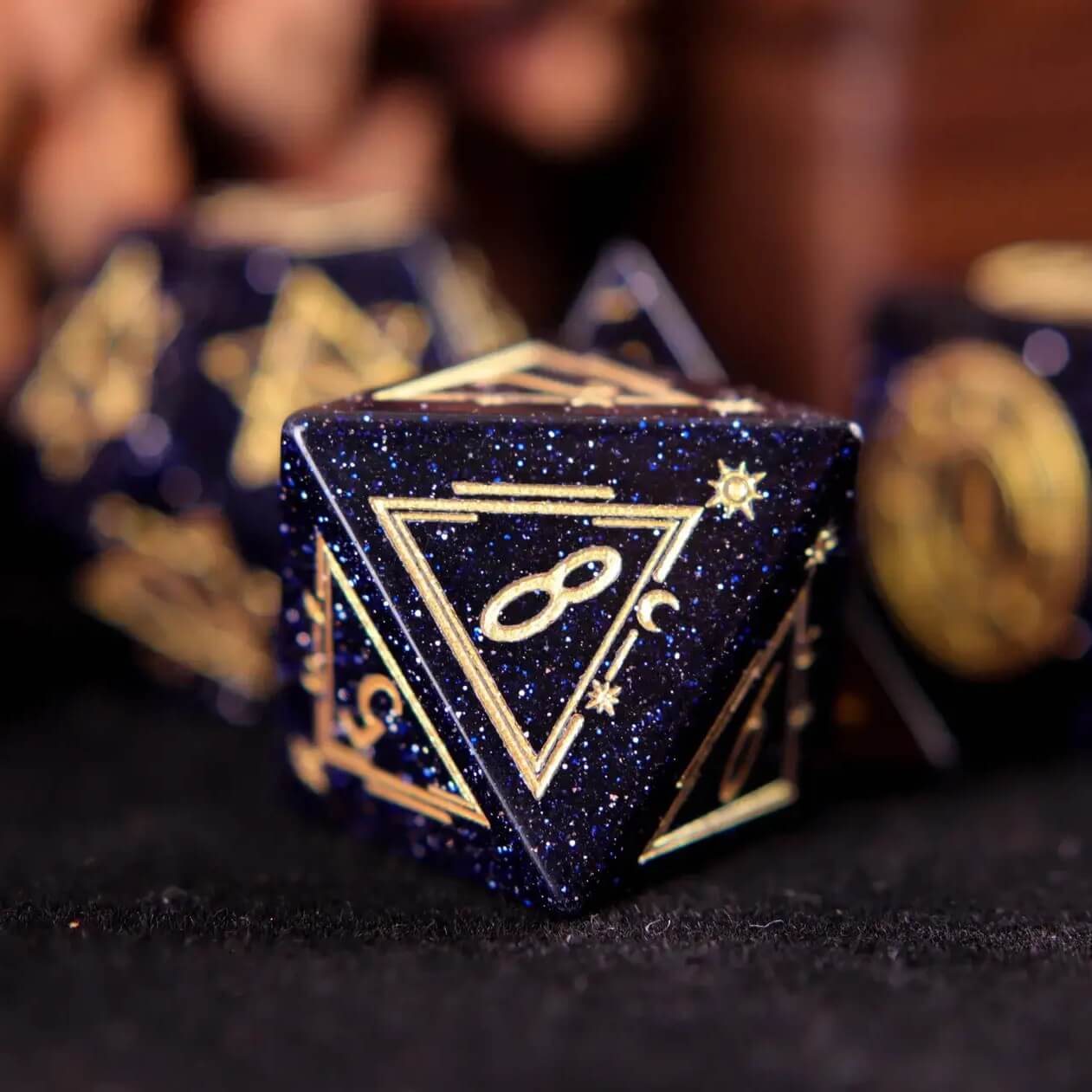 A set of D8 blue sandstone gemstone-carved dice on a black background