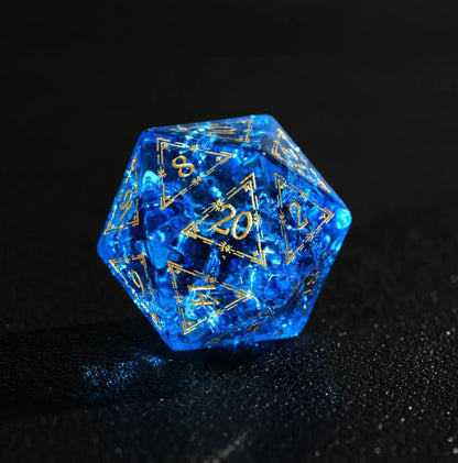 D20 closeup of the Eye of the Demon pattern on deep Blue Glass Dice. Sharp edges and gold numbering visible on the black surface.