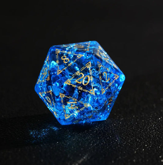 D20 closeup of the Eye of the Demon pattern on deep Blue Glass Dice. Sharp edges and gold numbering visible on the black surface.