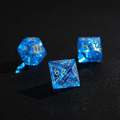 Three Blue Glass D6 dice side-by-side, emphasizing the clear gold numbers and the demon eye engraving.