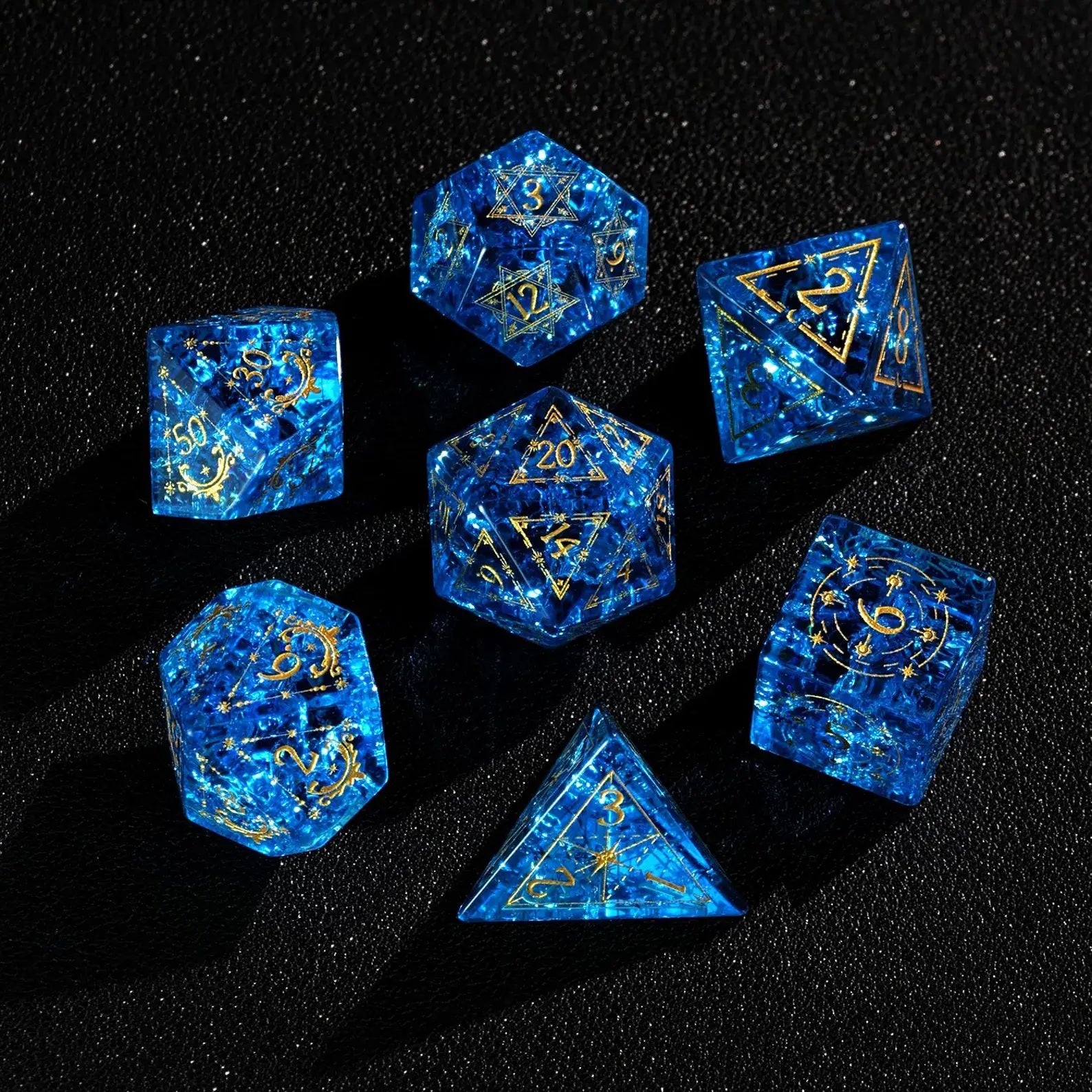 Full polyhedral set of Blue Glass Sharp Edge DND Dice on a black background. Highlighting the gold numbers and crystal clarity.
