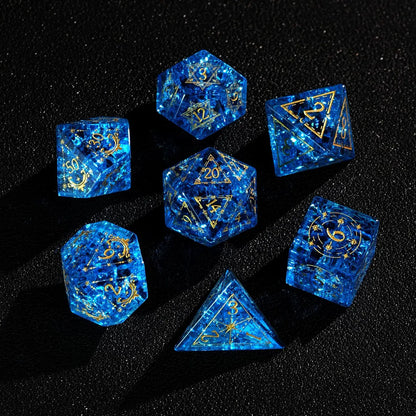 Full polyhedral set of Blue Glass Sharp Edge DND Dice on a black background. Highlighting the gold numbers and crystal clarity.