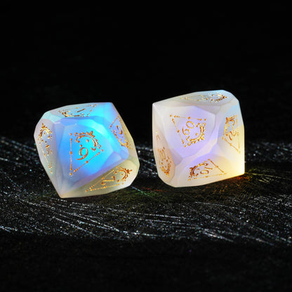 Frosted Aurora Opalite Glass Dice Set, close-up of a d6 showing ornate gold celestial engraving
