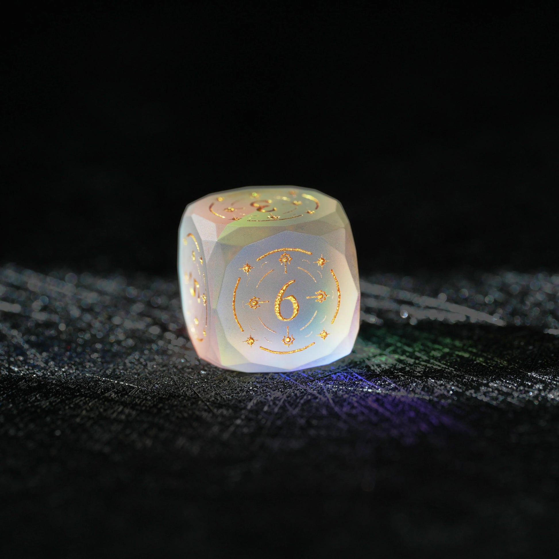 Frosted Aurora Opalite Glass Dice Set, close-up of a d6 showing ornate gold celestial engraving