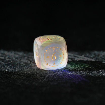 Frosted Aurora Opalite Glass Dice Set, close-up of a d6 showing ornate gold celestial engraving