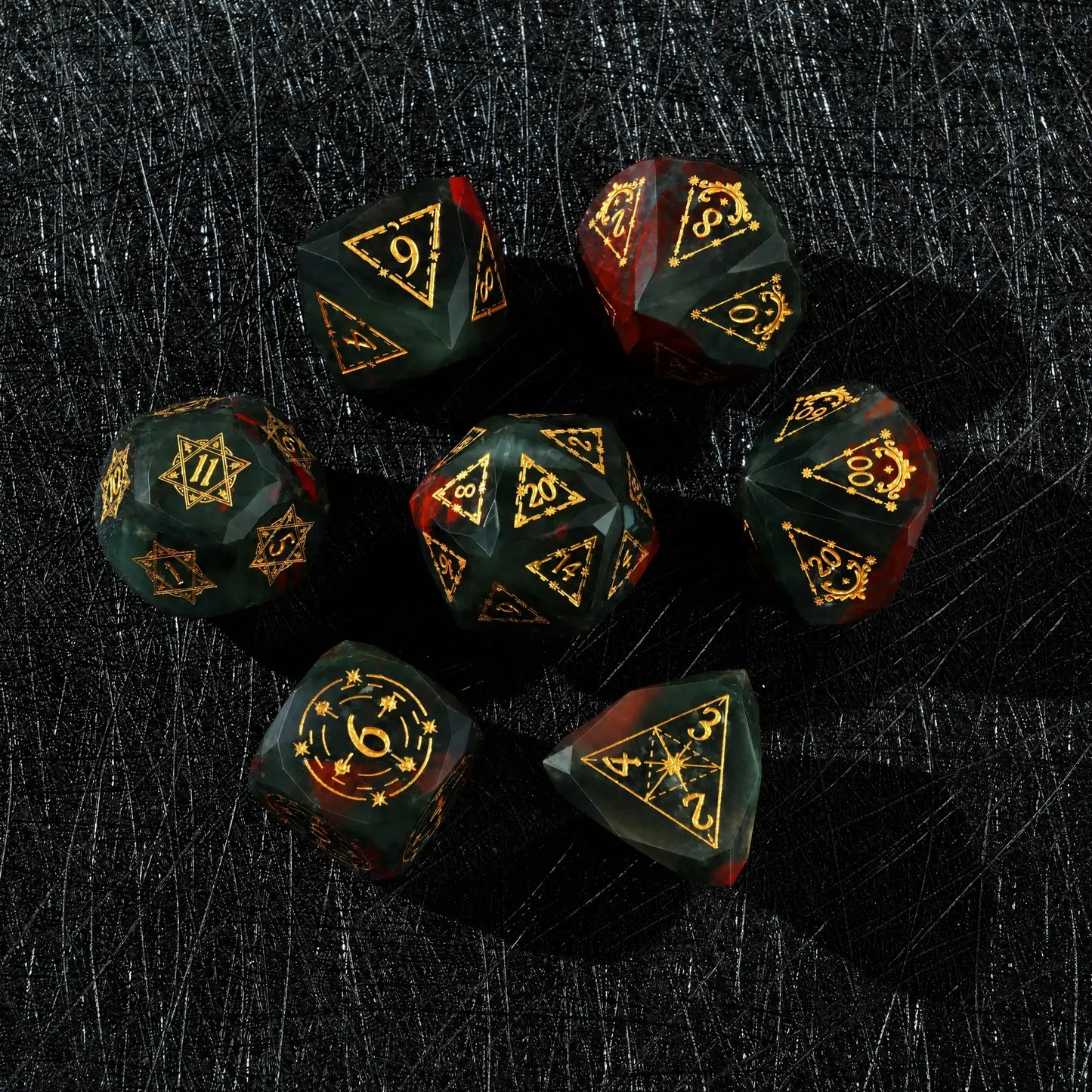 Celestial Bloodstone Gemstone Dice Set, close-up of two polyhedral dice with gold celestial numbers