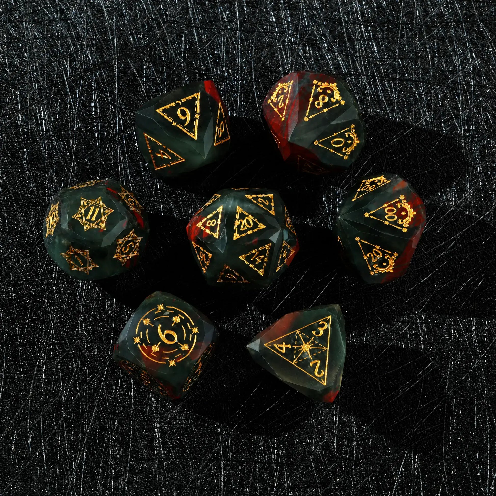 Celestial Bloodstone Gemstone Dice Set, close-up of two polyhedral dice with gold celestial numbers