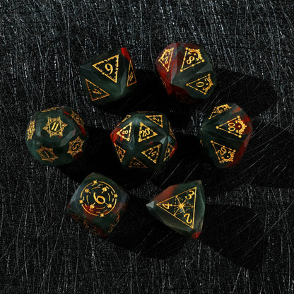 Celestial Bloodstone Gemstone Dice Set, close-up of two polyhedral dice with gold celestial numbers