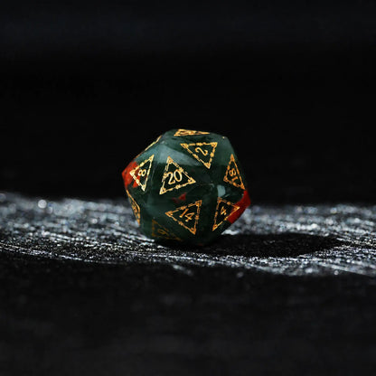 Celestial Bloodstone Gemstone Dice Set, single d20 on a dark tabletop background