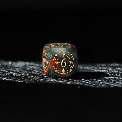 Celestial Bloodstone Gemstone Dice Set, close-up of a d6 showing ornate gold celestial engraving