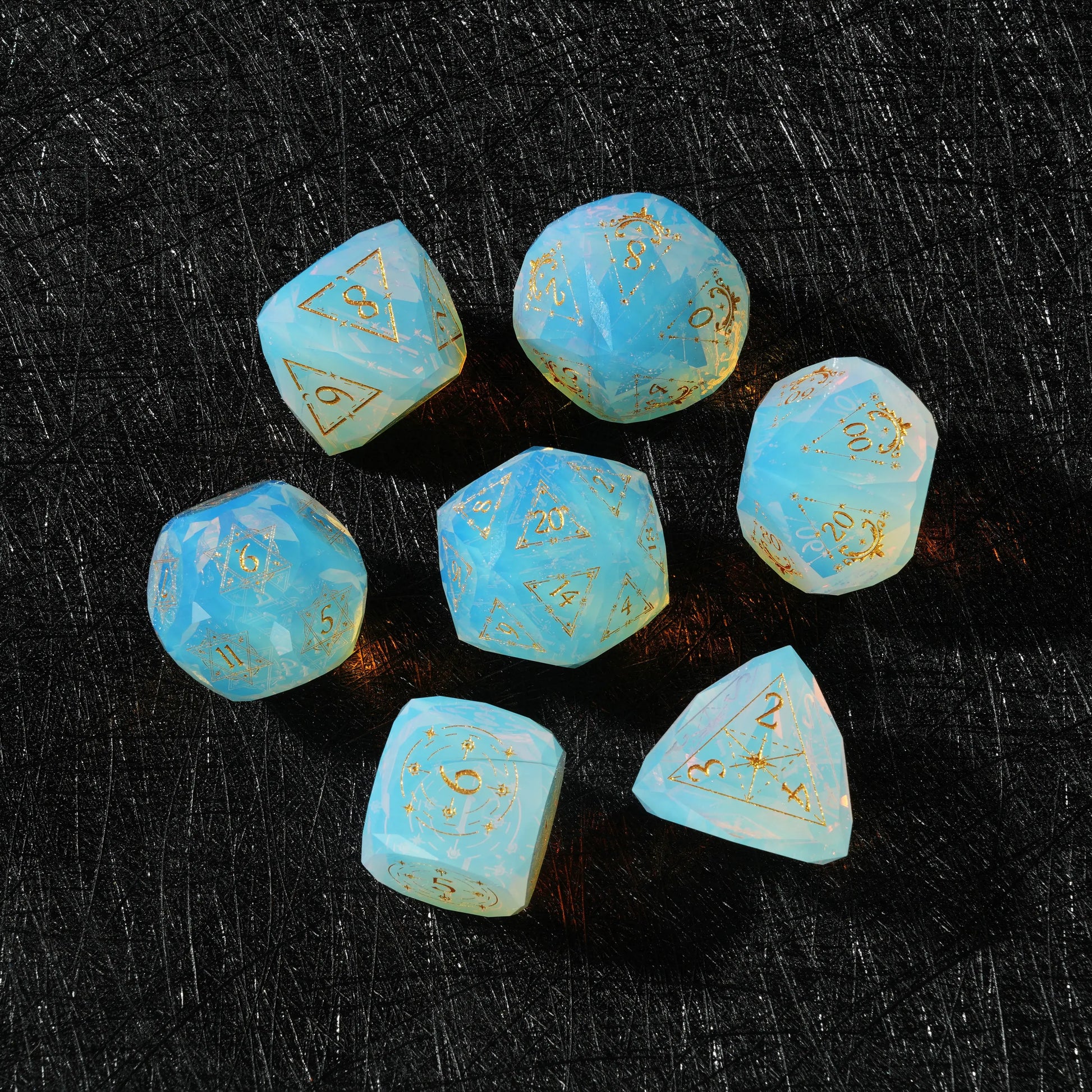 Sky Blue Opalite Glass Dice Set, close-up of two polyhedral dice with gold celestial numbers
