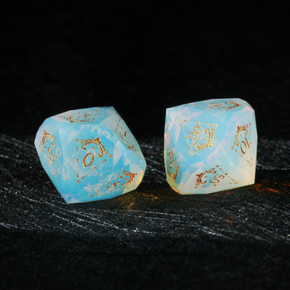 Sky Blue Opalite Glass Dice Set, close-up of two polyhedral dice with gold celestial numbers