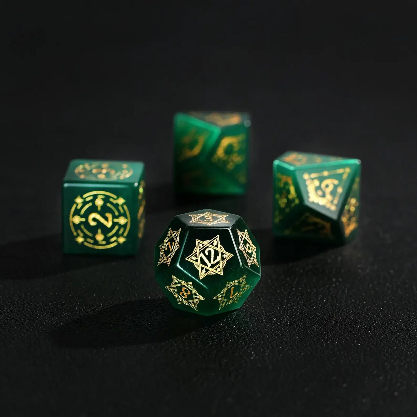 Elegant arrangement of four Dare Green Cat's Eye Dice (D4, D6, D8, D12) with Gold Inking on a solid black background, showcasing the striking color and luminous shine.
