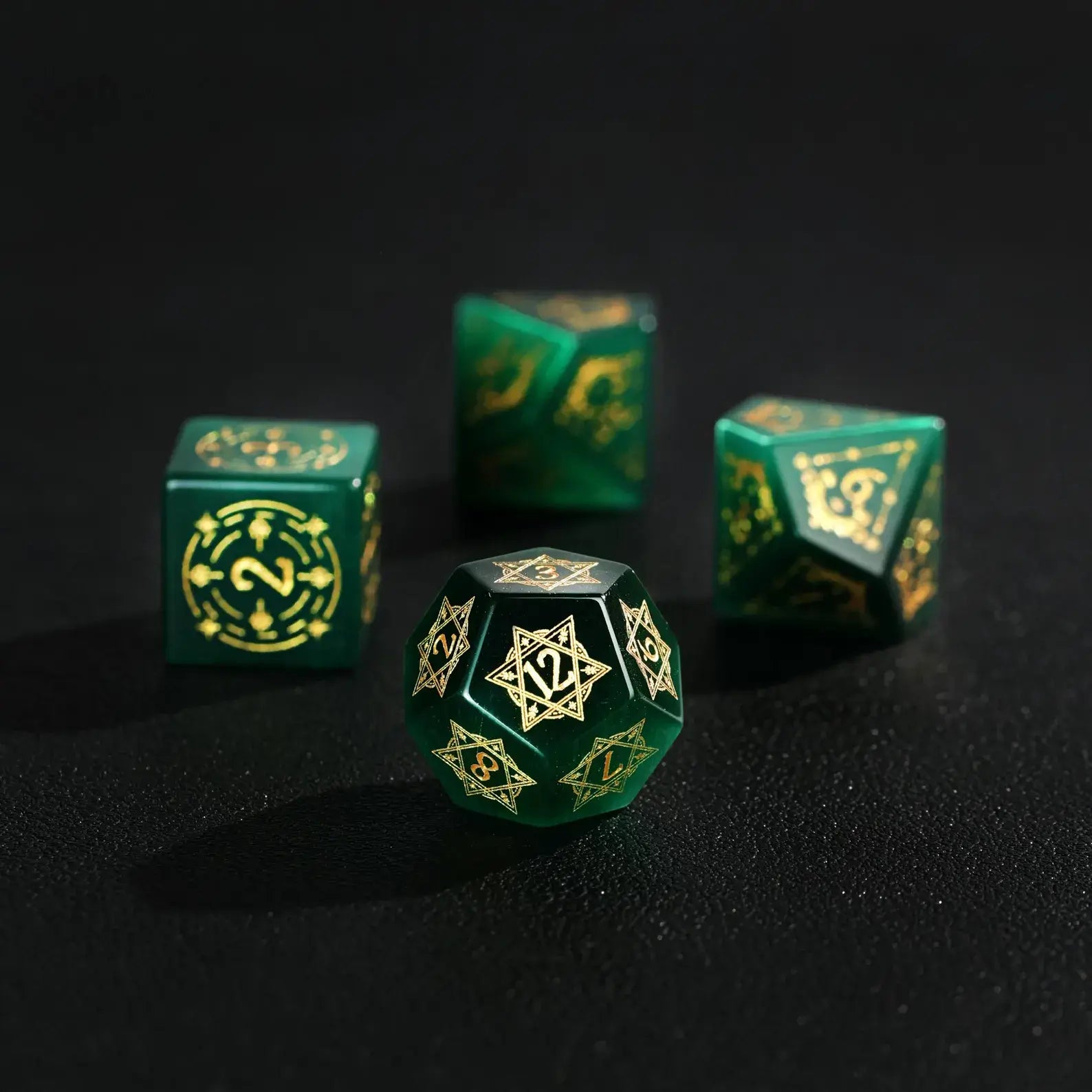 Elegant arrangement of four Dare Green Cat's Eye Dice (D4, D6, D8, D12) with Gold Inking on a solid black background, showcasing the striking color and luminous shine.
