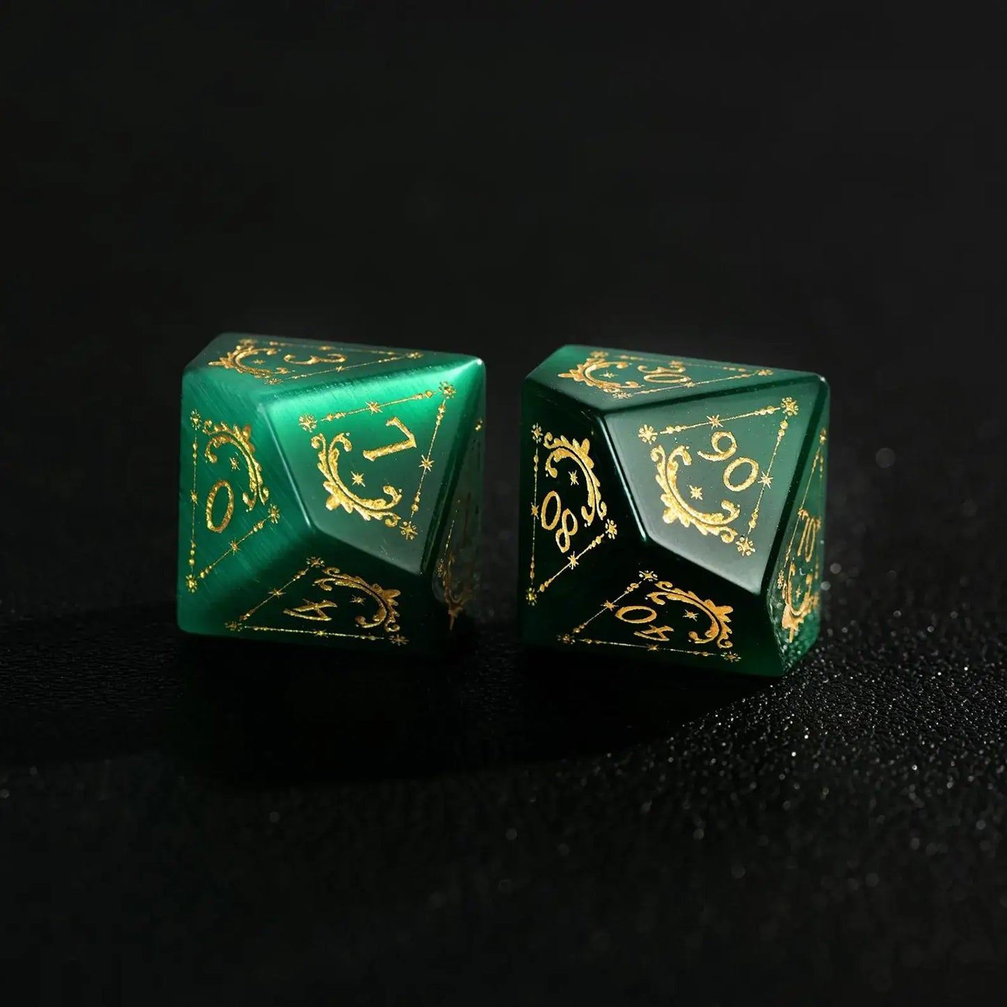 Two Handcrafted DND Dare Green Cat's Eye Polyhedral Dice (D4 and D6) featuring Gold Inking, resting on a black surface, emphasizing the quality and rich color.
