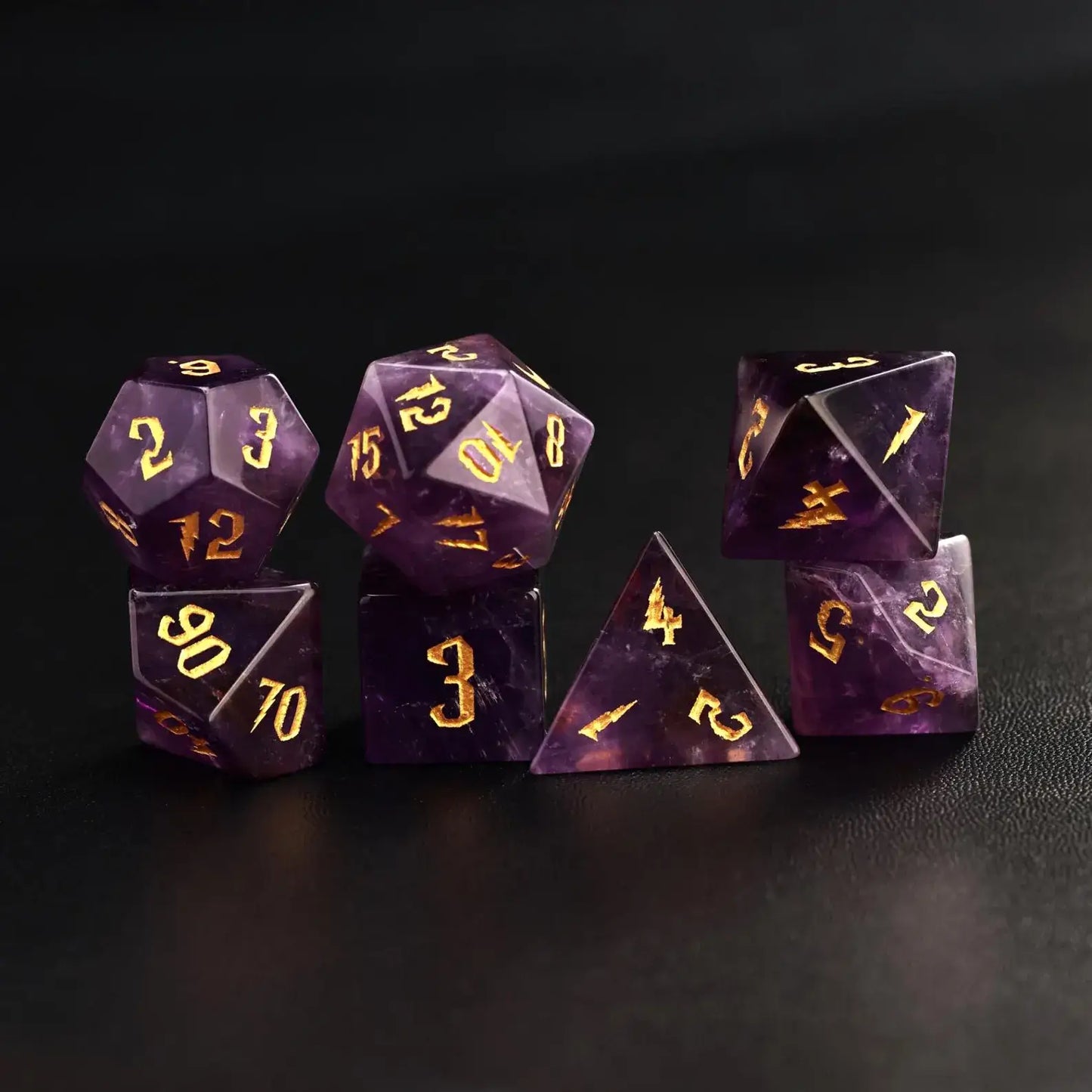 Complete 7-piece set of amethyst gemstone DND dice (D4-D20) with gold moon engravings on black leather, professional RPG gear.