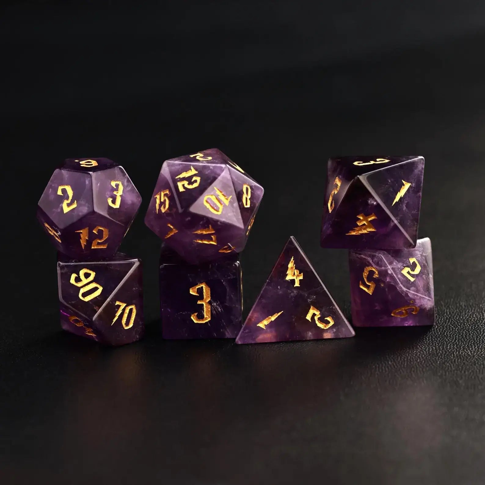 Complete 7-piece set of amethyst gemstone DND dice (D4-D20) with gold moon engravings on black leather, professional RPG gear.