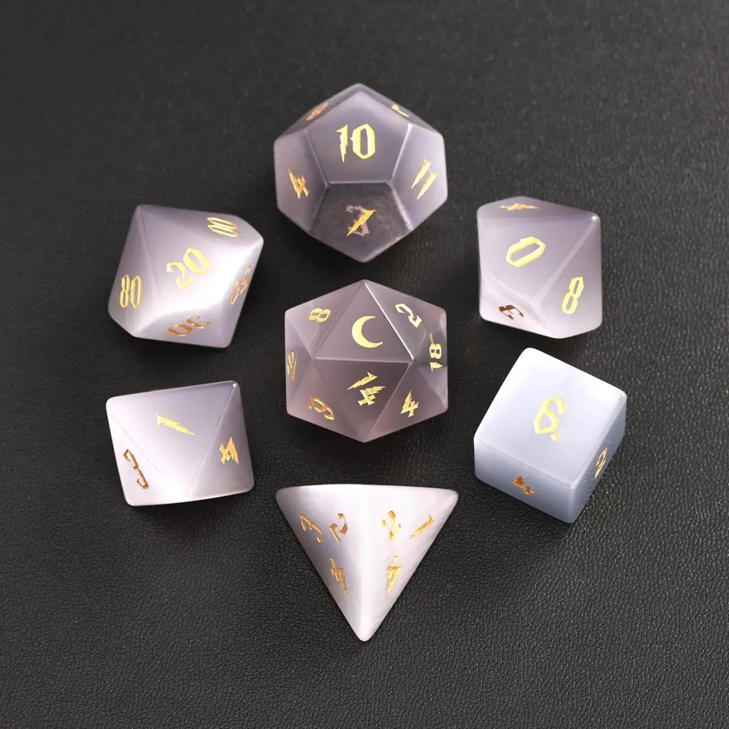 The complete 7-piece Grey Cat's Eye Gemstone Dice Set (D4-D20) fully displayed on a black background, the essential Polyhedral Dice collection.