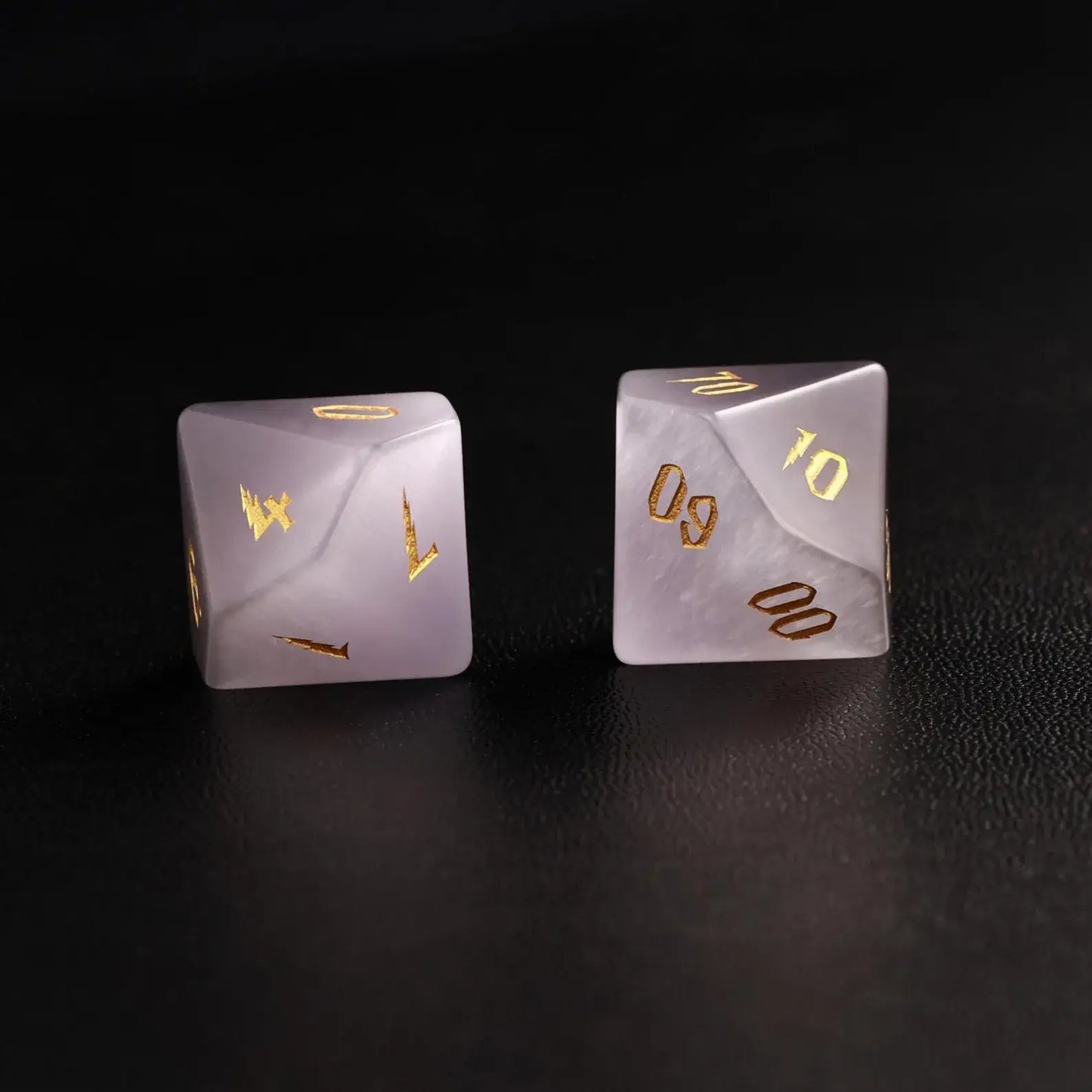 wo Handcrafted DND Grey Cat's Eye Polyhedral Dice (D4 and D6) resting on a black surface, emphasizing the quality of the natural stone material and neutral tone