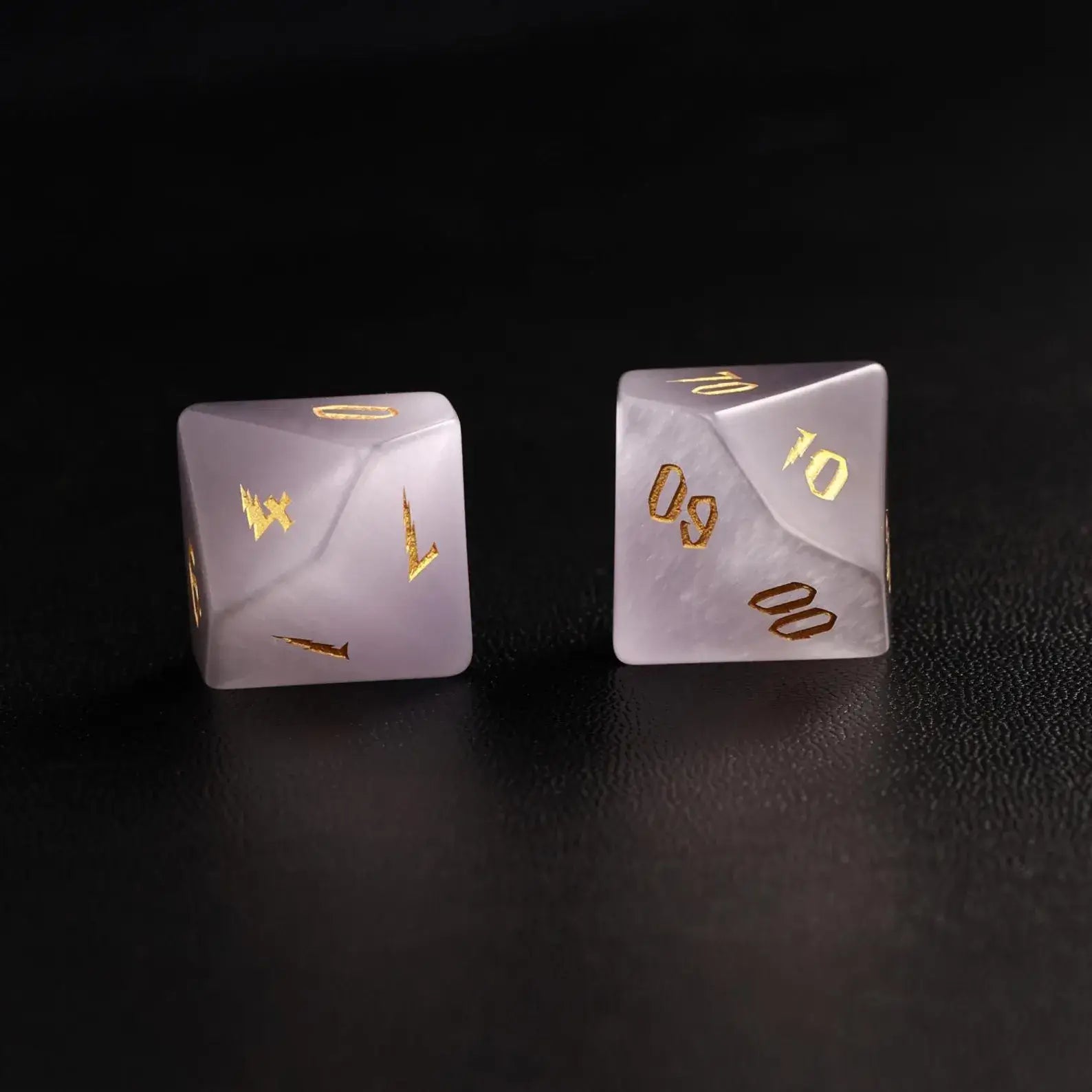 wo Handcrafted DND Grey Cat's Eye Polyhedral Dice (D4 and D6) resting on a black surface, emphasizing the quality of the natural stone material and neutral tone
