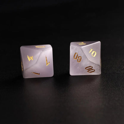 wo Handcrafted DND Grey Cat's Eye Polyhedral Dice (D4 and D6) resting on a black surface, emphasizing the quality of the natural stone material and neutral tone
