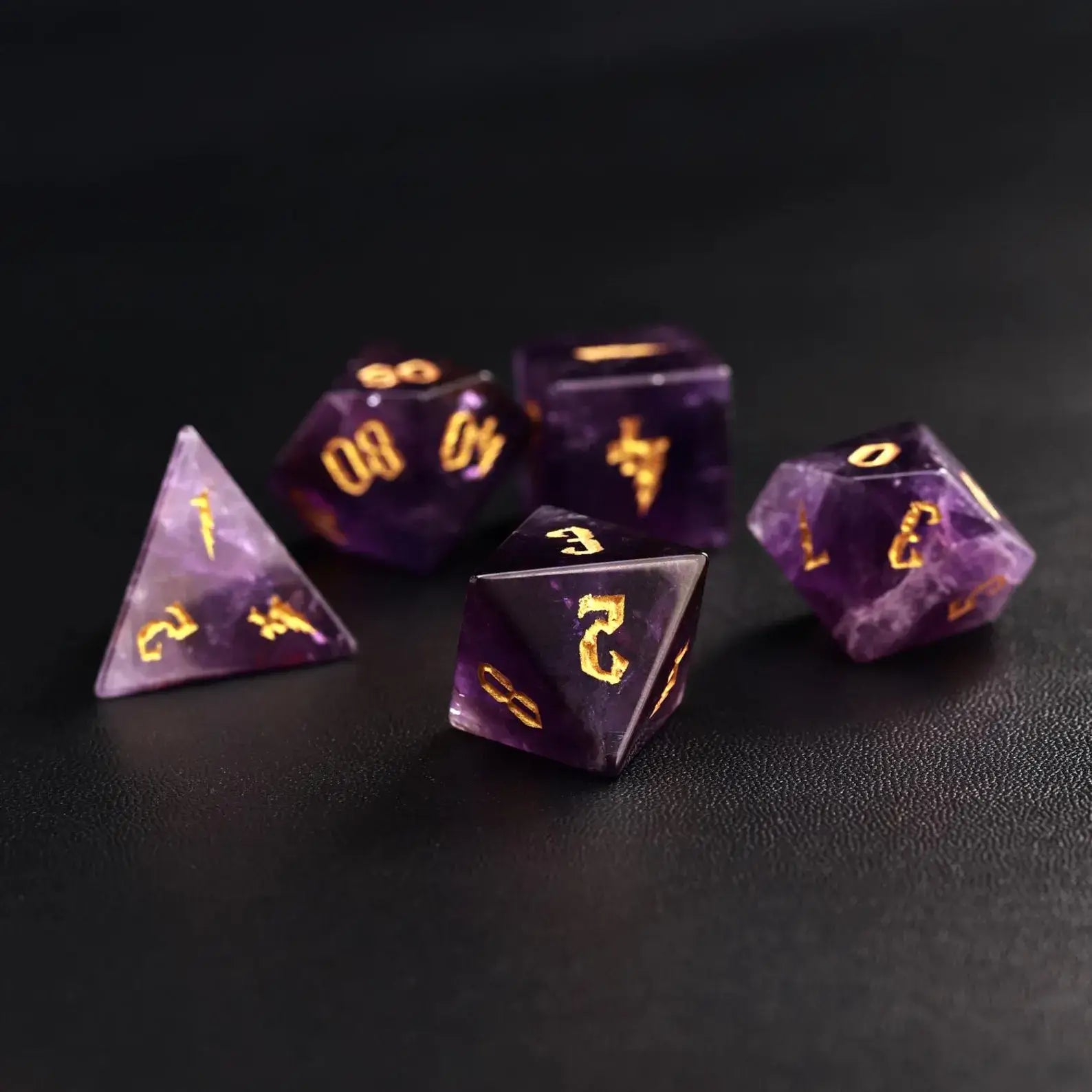 A collection of five amethyst dice with gold moon phases, perfect for Lunar Sorcerer or Druid characters in Dungeons and Dragons.