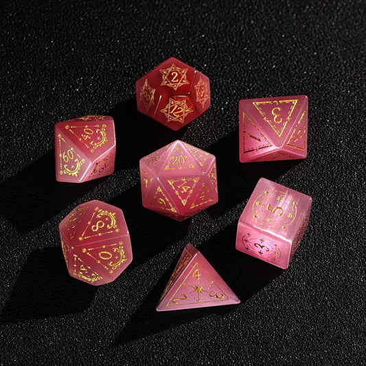 The complete 7-piece Pink Cat's Eye Gemstone Dice Set (D4-D20) fully displayed on a black background, the essential Polyhedral Dice collection.