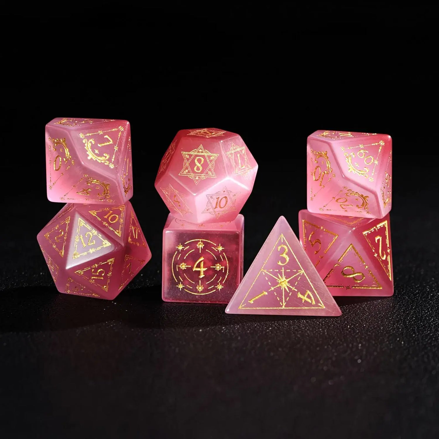 The complete 7-piece Pink Cat's Eye Gemstone Dice Set (D4-D20) fully displayed on a black background, the essential Polyhedral Dice collection.