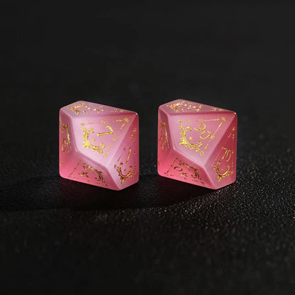 Two Handcrafted DND Pink Cat's Eye Polyhedral Dice (D4 and D6) resting on a black surface, emphasizing the quality of the natural stone material.