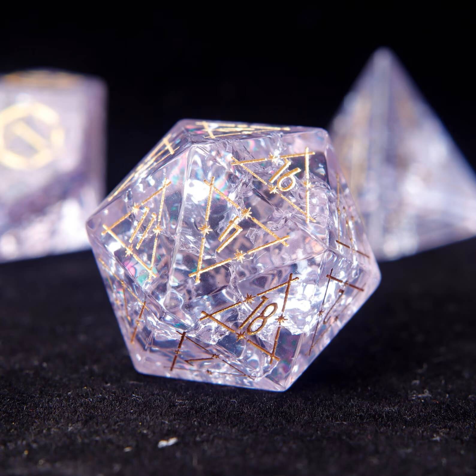 D20 closeup of the Eye of the Demon pattern on vibrant Pink Glass Dice. Sharp edges and gold numbering visible on the black surface.