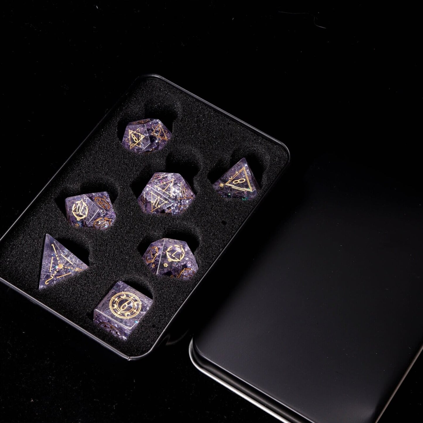 Pink Sharp Edge Dice Set presented inside the open Iron Dice Storage Box. Shows secure dice collection storage.