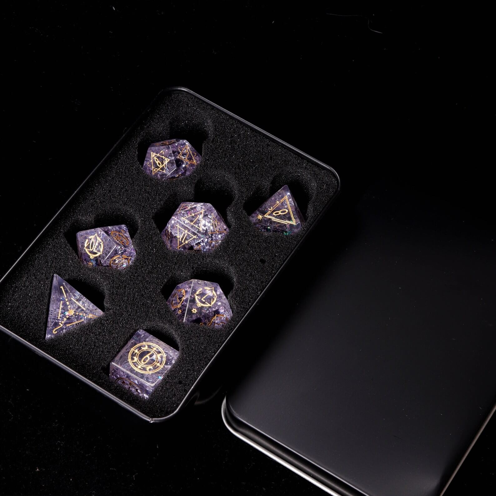 Pink Sharp Edge Dice Set presented inside the open Iron Dice Storage Box. Shows secure dice collection storage.