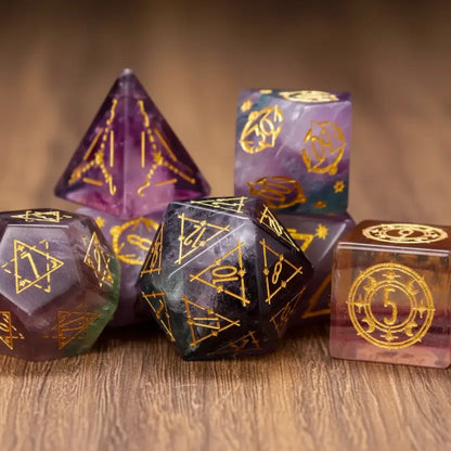 An artful, scattered arrangement of seven engraved purple fluorite gemstone dice for Dungeons & Dragons on a rustic walnut table.
