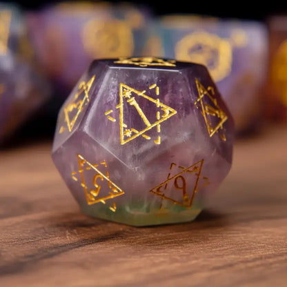 Solo shot of a deep purple fluorite D12 die with engraved numbers, presented on a rich walnut wood surface.