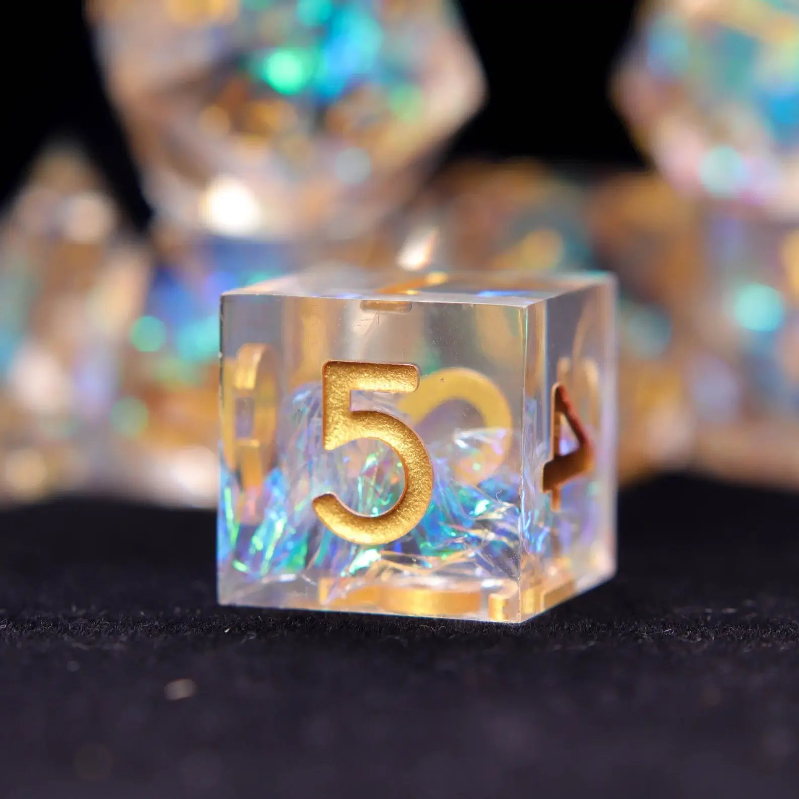 Transparent resin D6 with gold numbers showing balanced shape for consistent tabletop RPG gameplay