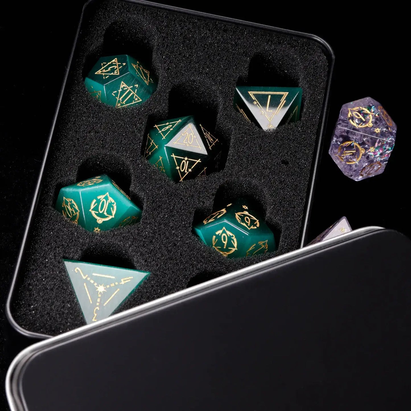 Top-down view of the full dark green cat's eye gemstone dice set on a black surface, highlighting the unique engraved numerals on each die.